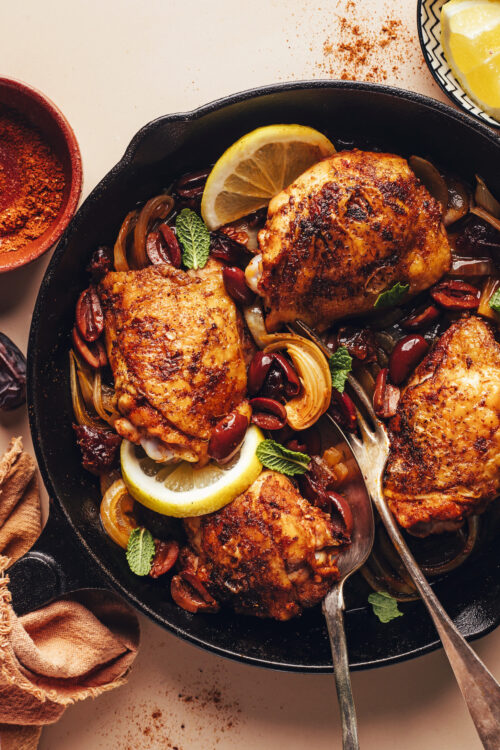 Crispy baked mediterranean chicken thighs in a cast iron skillet