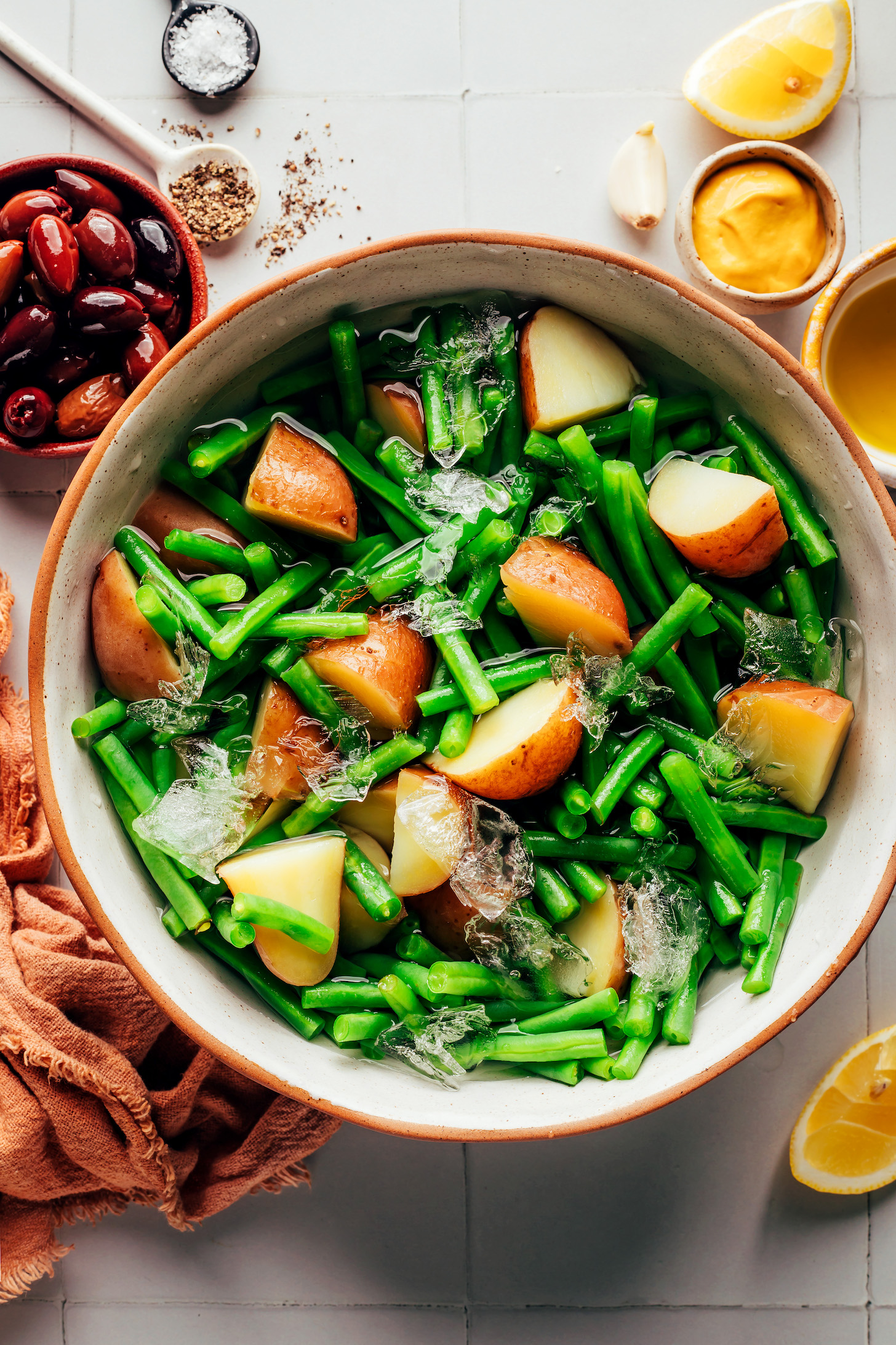 Boiled potatoes and blanched green beans in an ice water bath