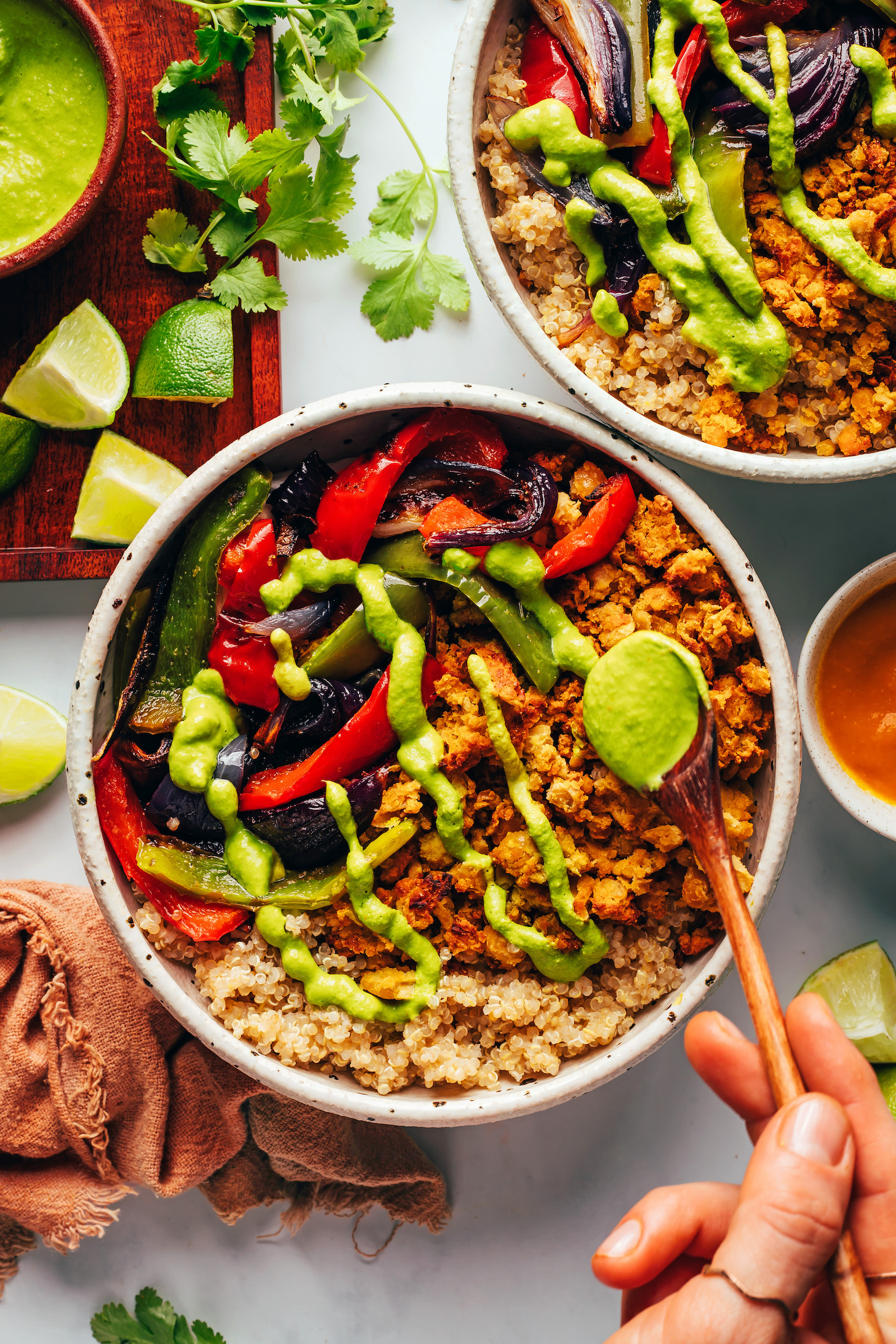 Drizzling aji verde sauce over a smashed chickpea taco bowl