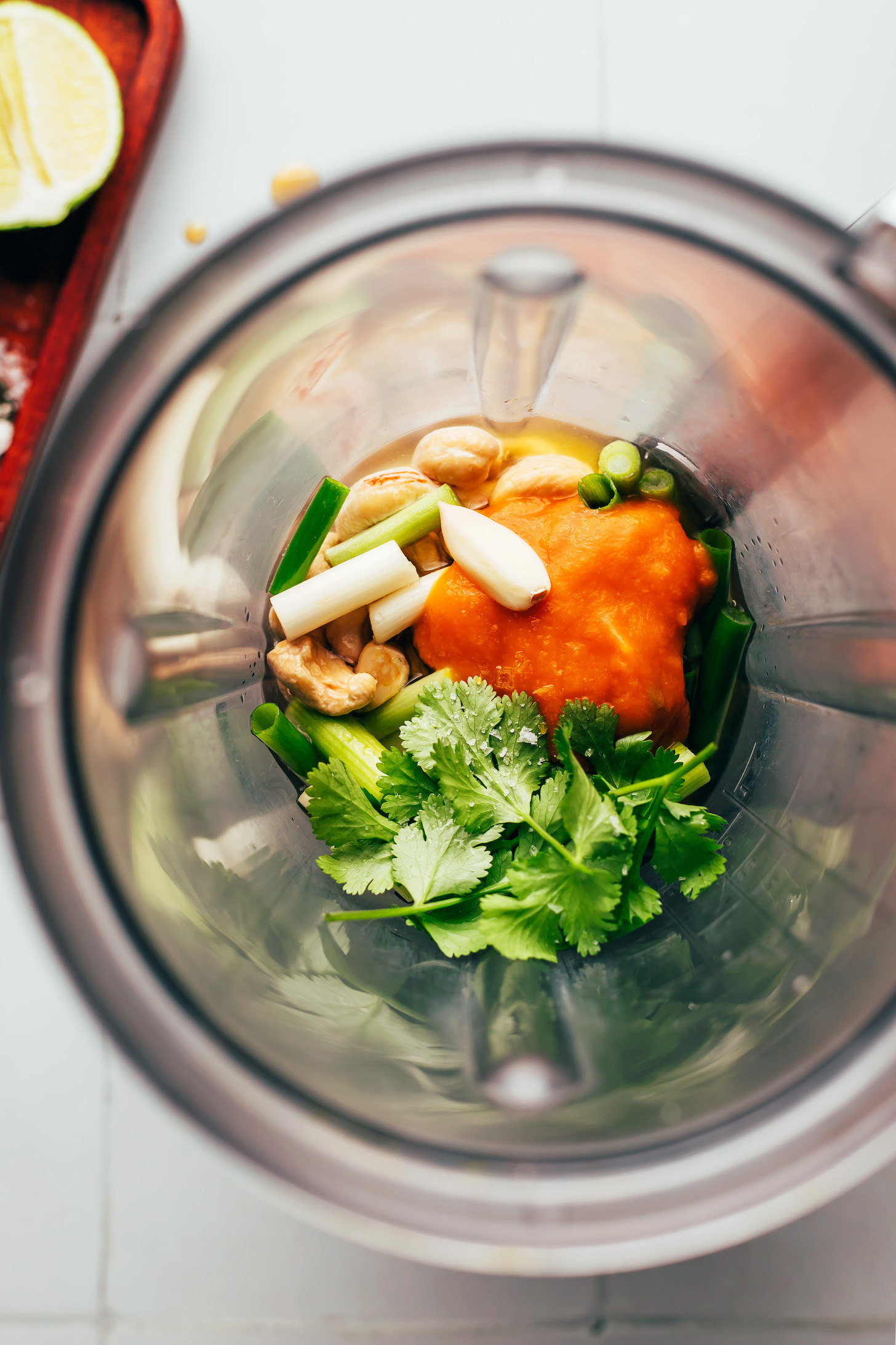 Blender with cashews, aji amarillo paste, green onion, garlic, cilantro, and water