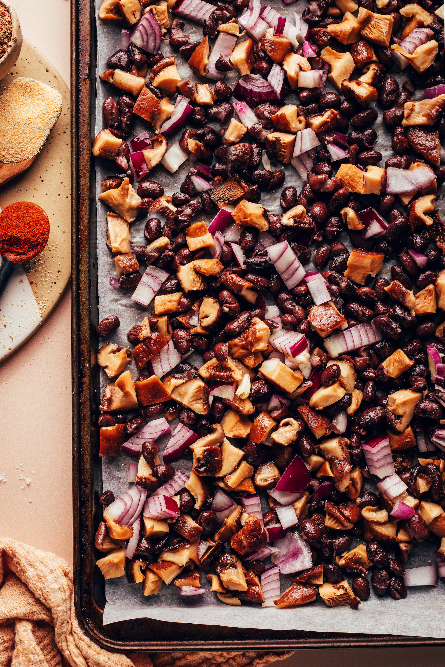 Black beans, red onion, and mushrooms on a baking sheet