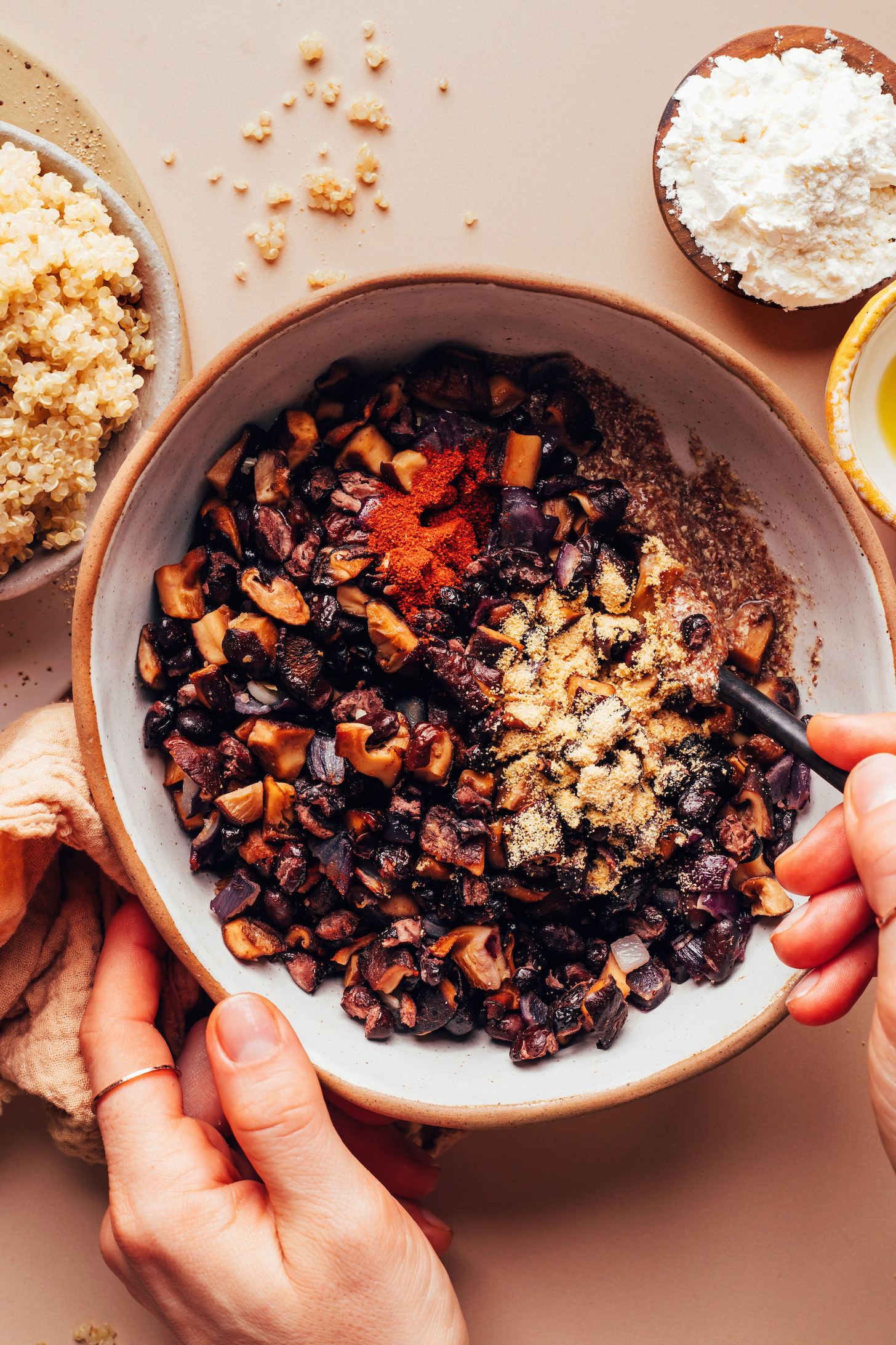 Stirring roasted vegetables, flax egg, and spices in a bowl