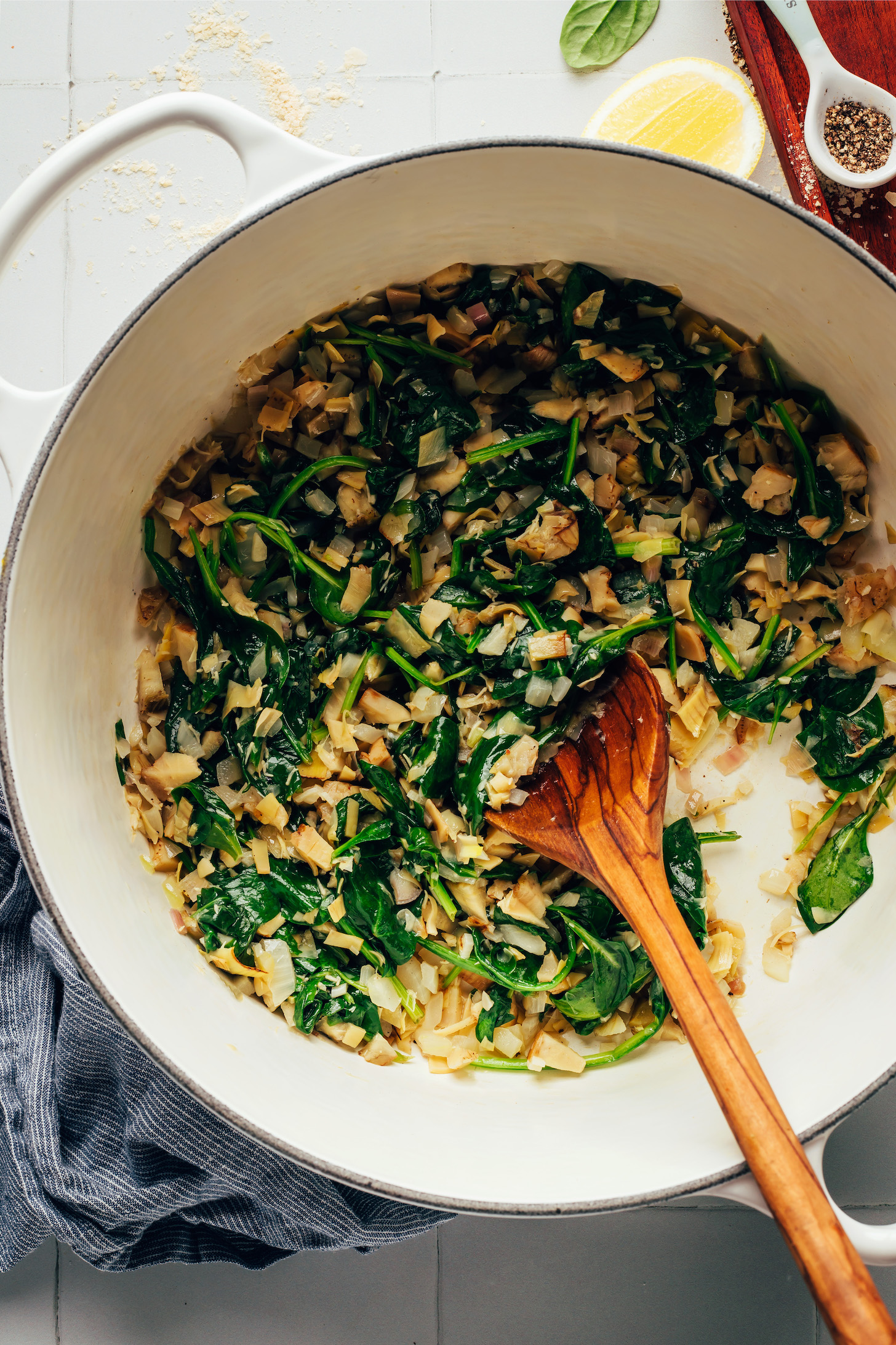 Sautéing shallot, garlic, artichoke hearts, and spinach in a Dutch oven