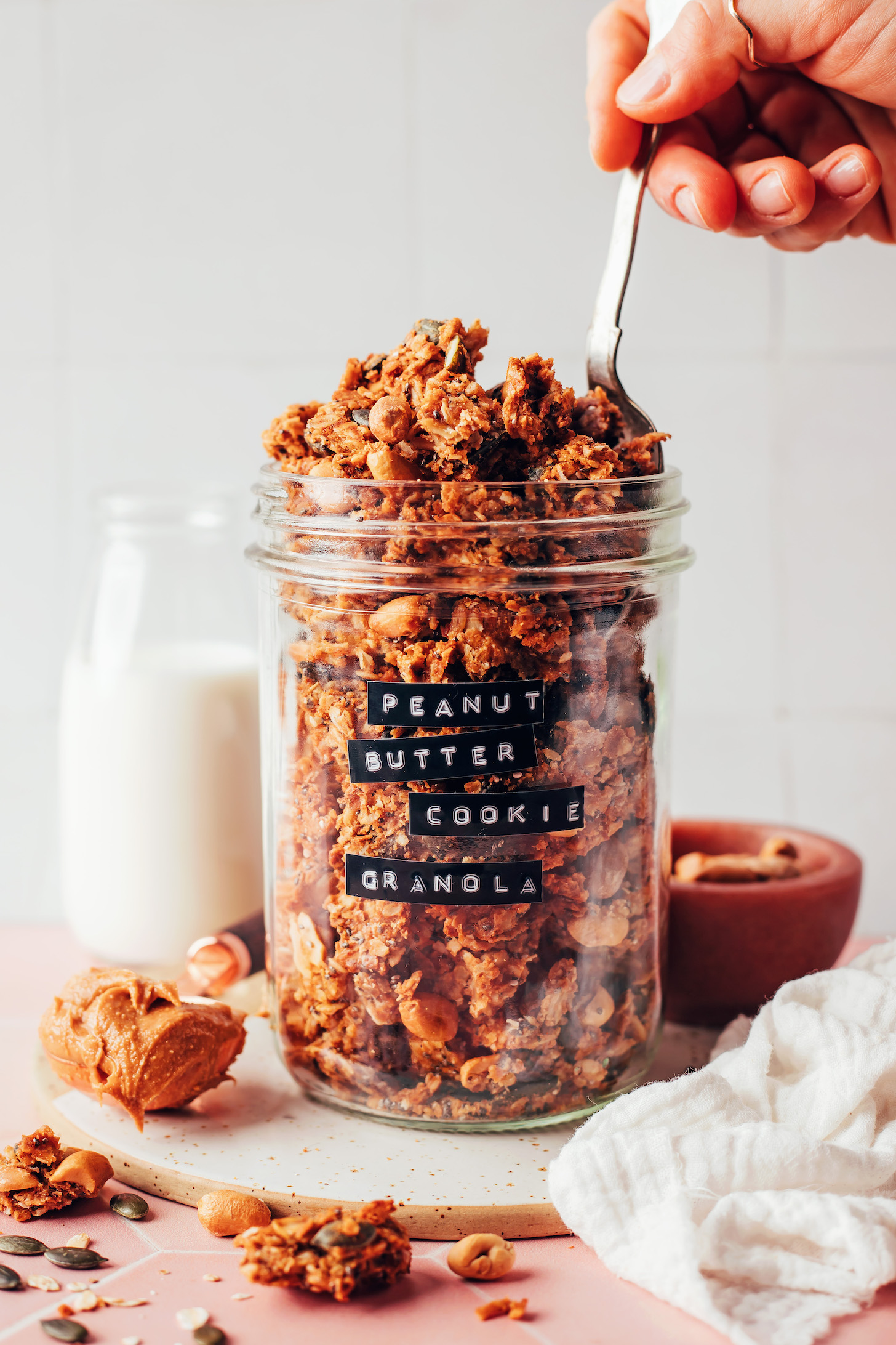 Sticking a spoon into a jar of peanut butter cookie granola