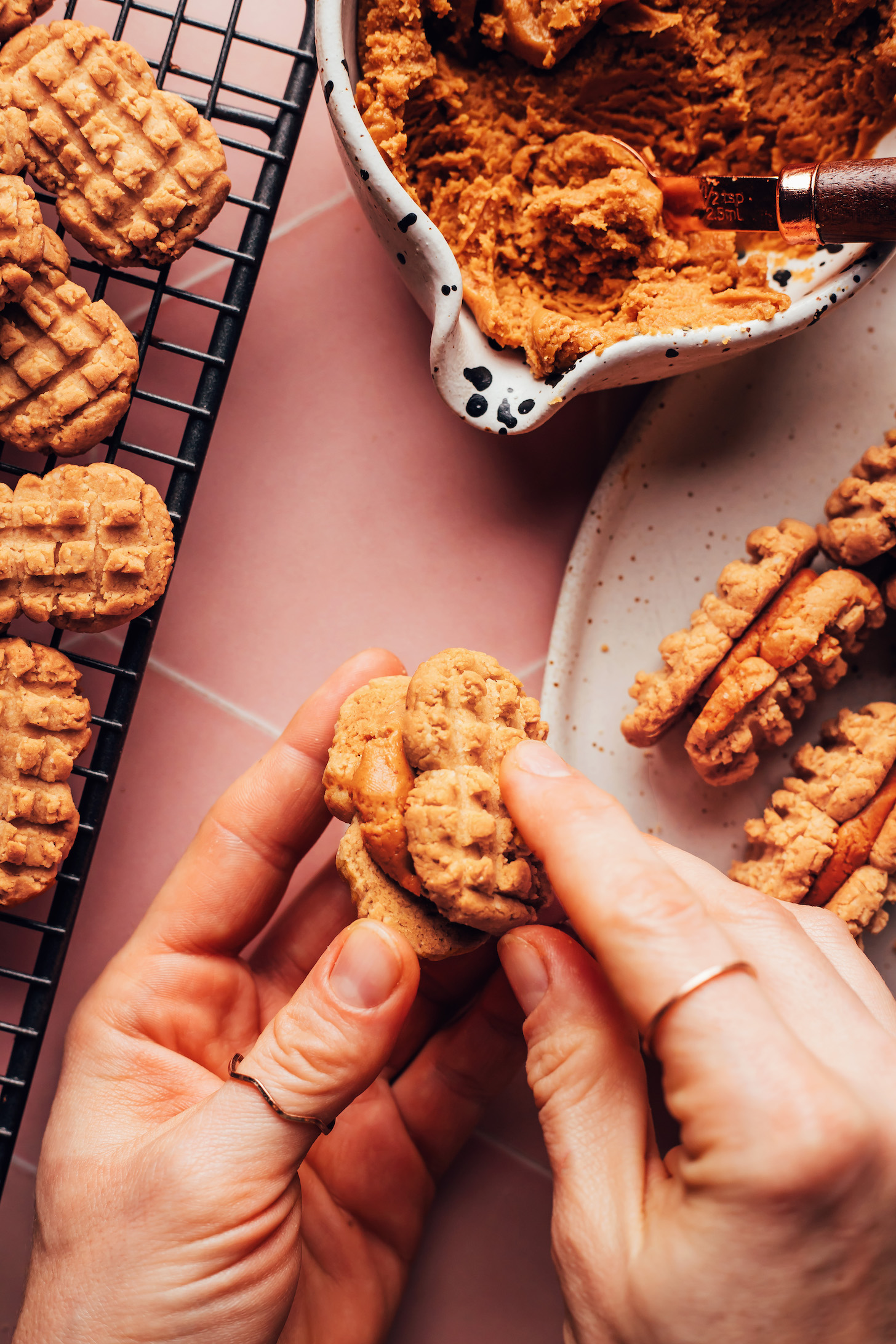 Assembling a Nutter Butter cookie by sandwiching two peanut butter cookies with a creamy peanut butter filling