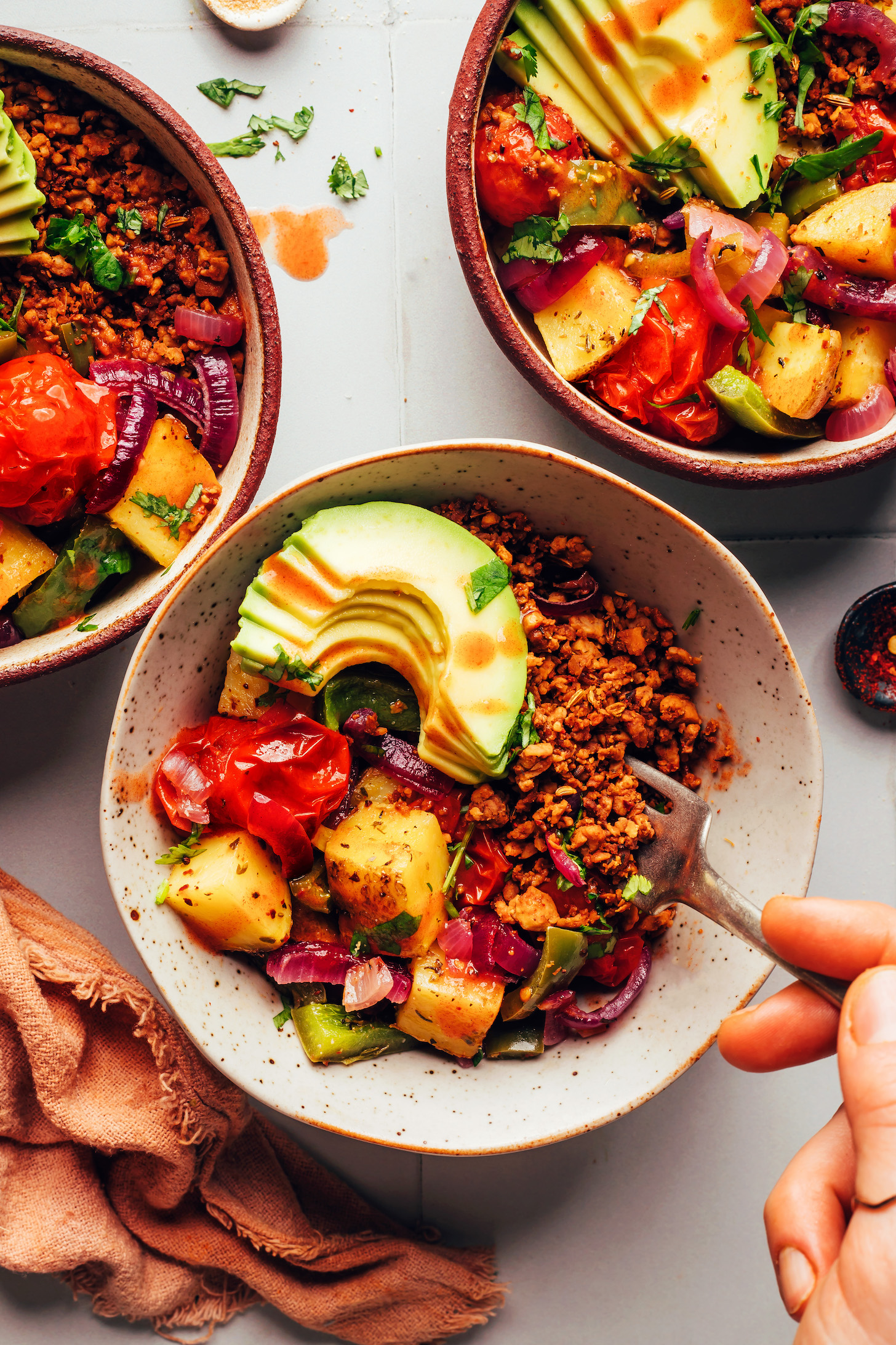 Using a fork to pick up a bite of tempeh sausage crumbles