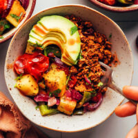 Fork grabbing a bite of vegan sausage crumbles from a breakfast bowl