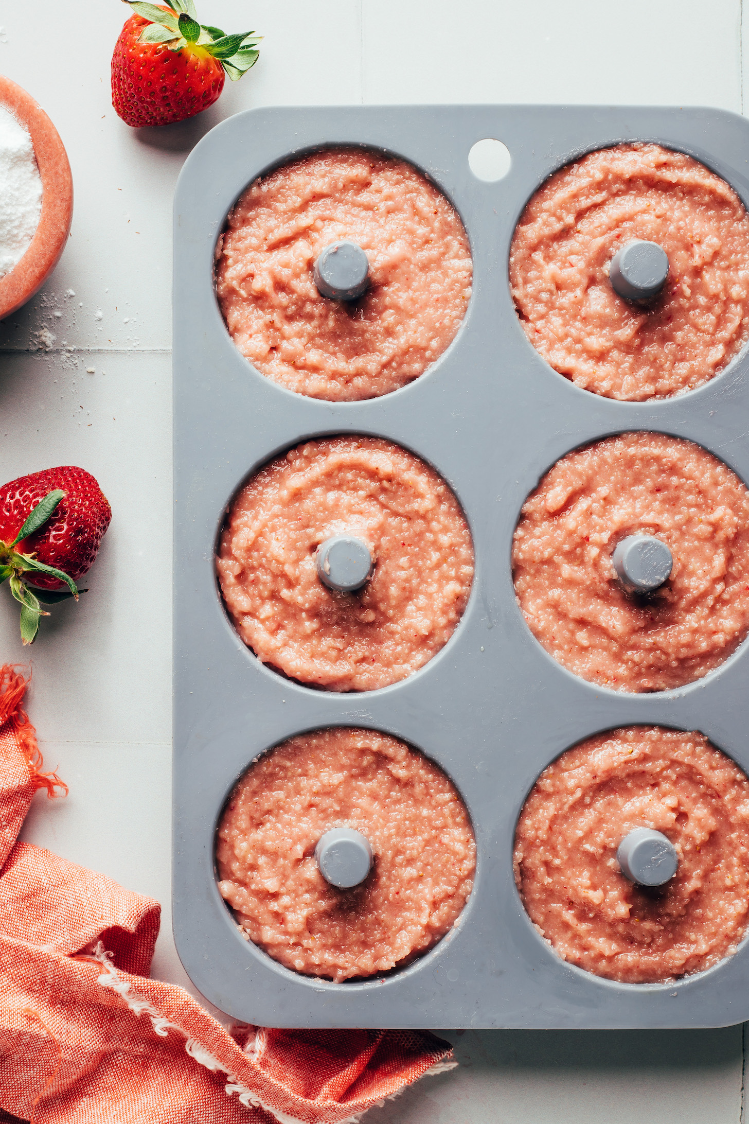 Strawberry donut batter in a donut pan