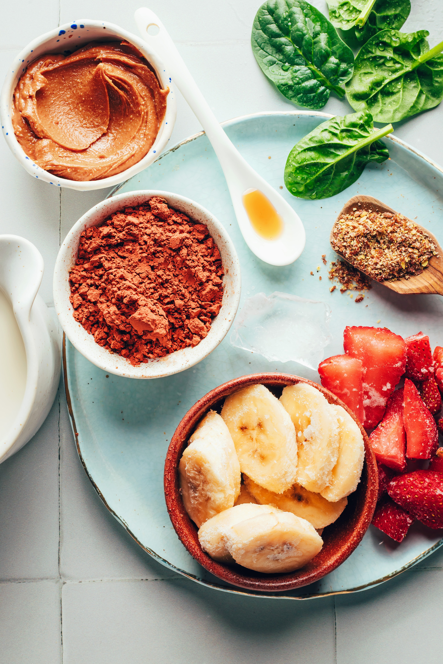 Frozen banana, frozen strawberries, flaxseed meal, spinach, agave, cocoa powder, almond butter, and dairy-free milk