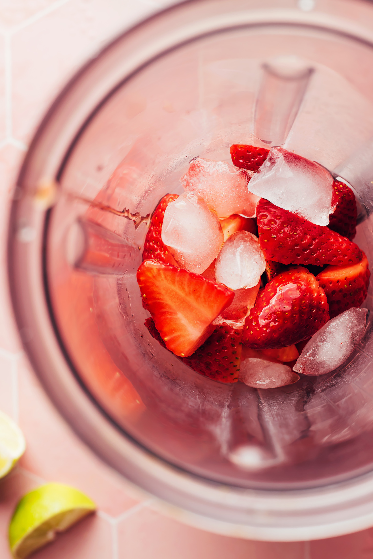 Strawberries, maple syrup, lime juice, tequila, and ice in a blender
