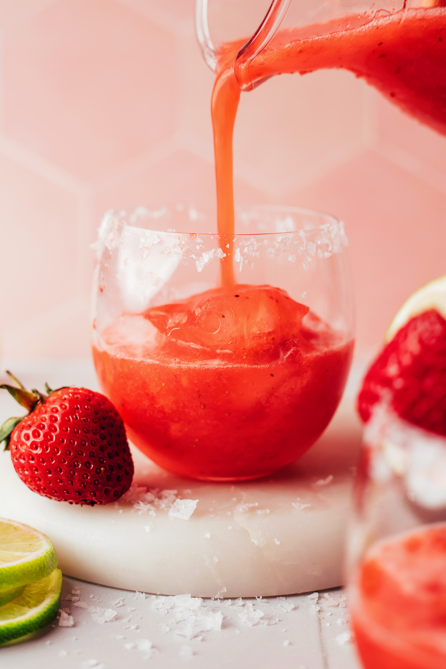 Pouring a strawberry margarita over ice