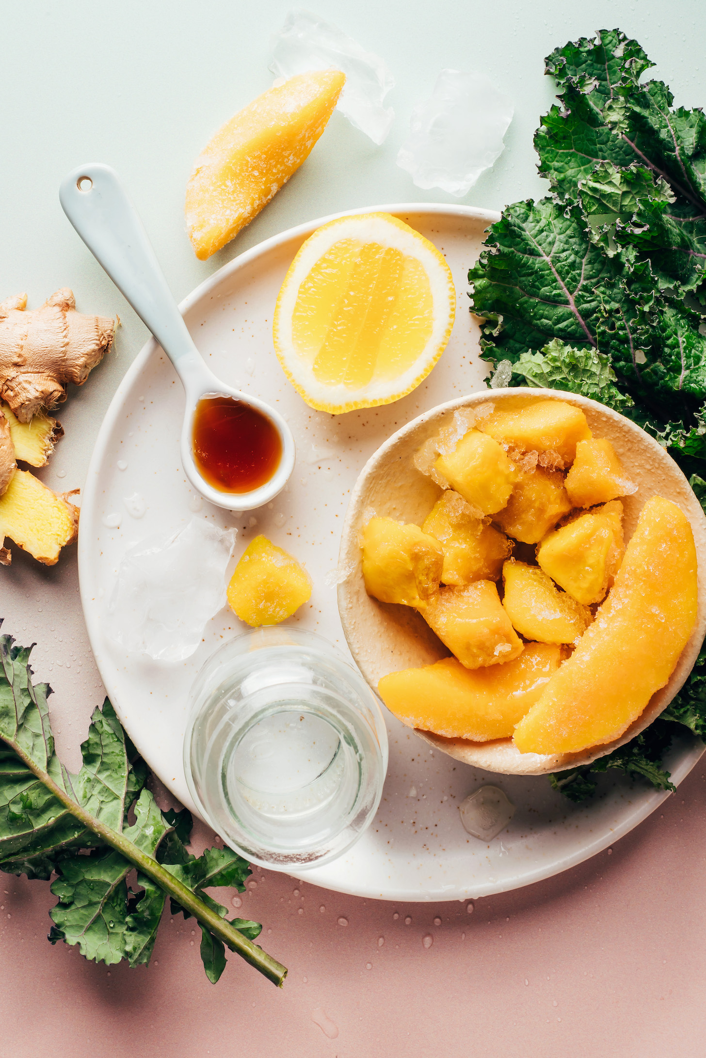 Frozen mango, frozen peaches, kale, lemon, maple syrup, water, ice, and ginger