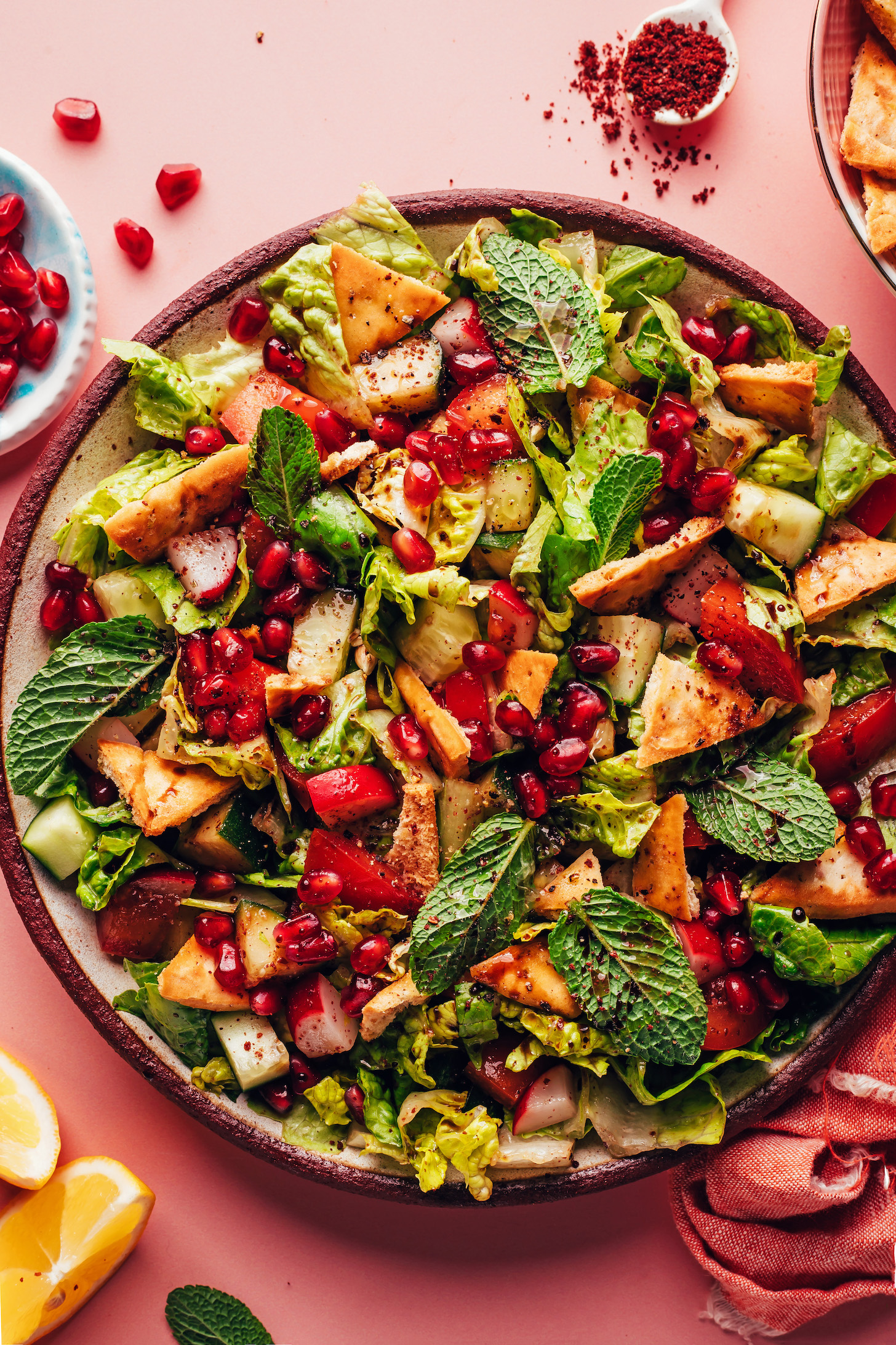 Plate of our easy fattoush salad with pita chips, mint, pomegranate arils, cucumber, and romaine