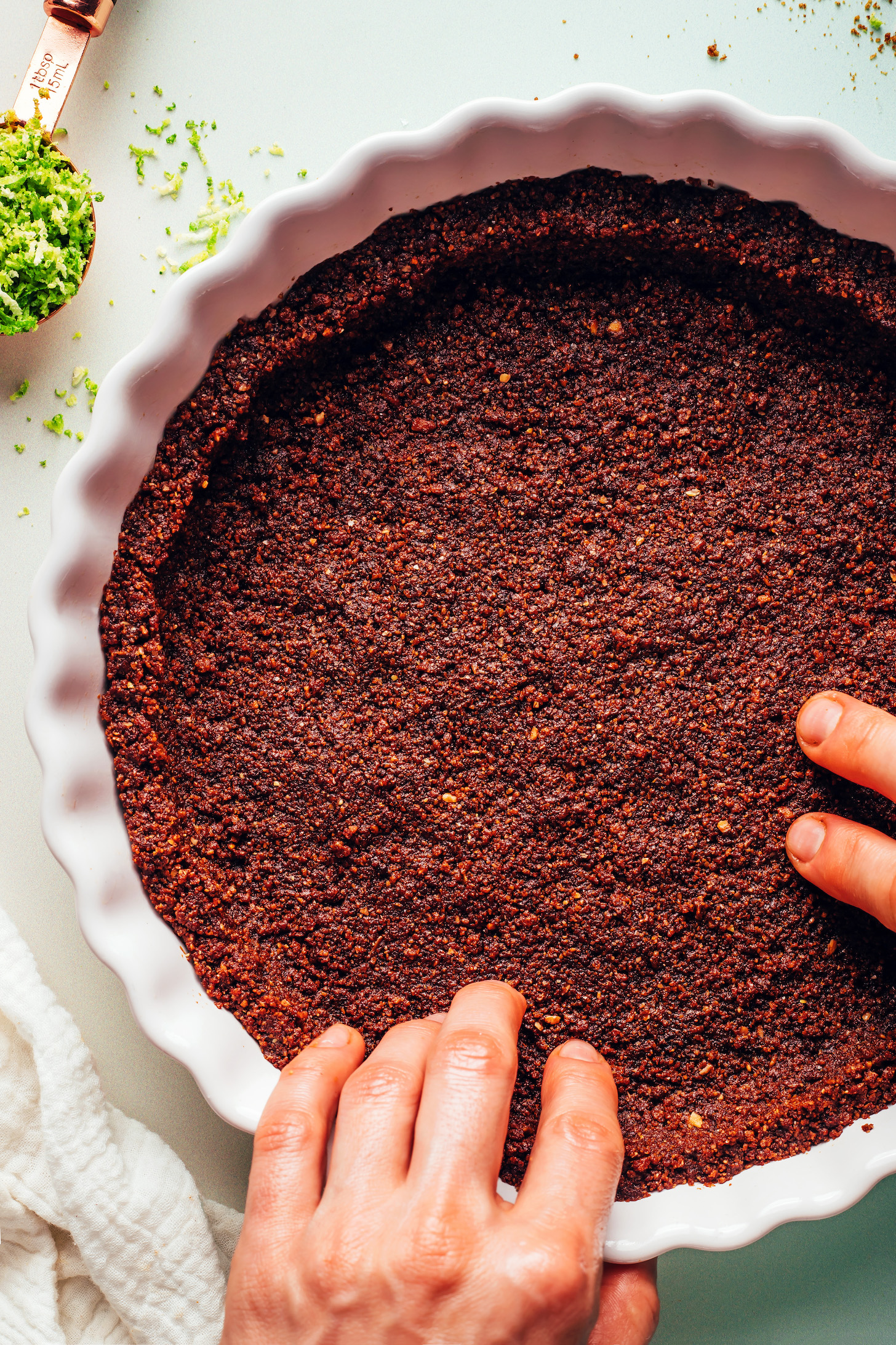 Pressing a gluten-free graham cracker crust into a pie pan