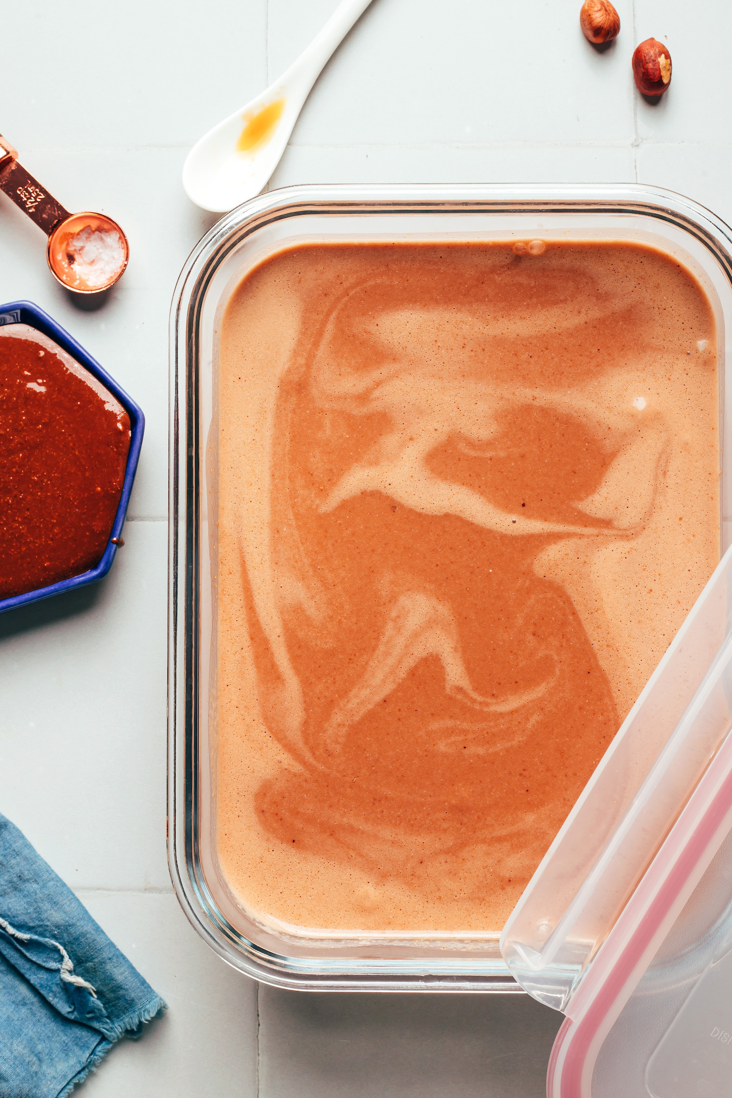 Glass container with a blended mixture of dairy-free chocolate hazelnut spread, coconut milk, sugar, vanilla, and salt