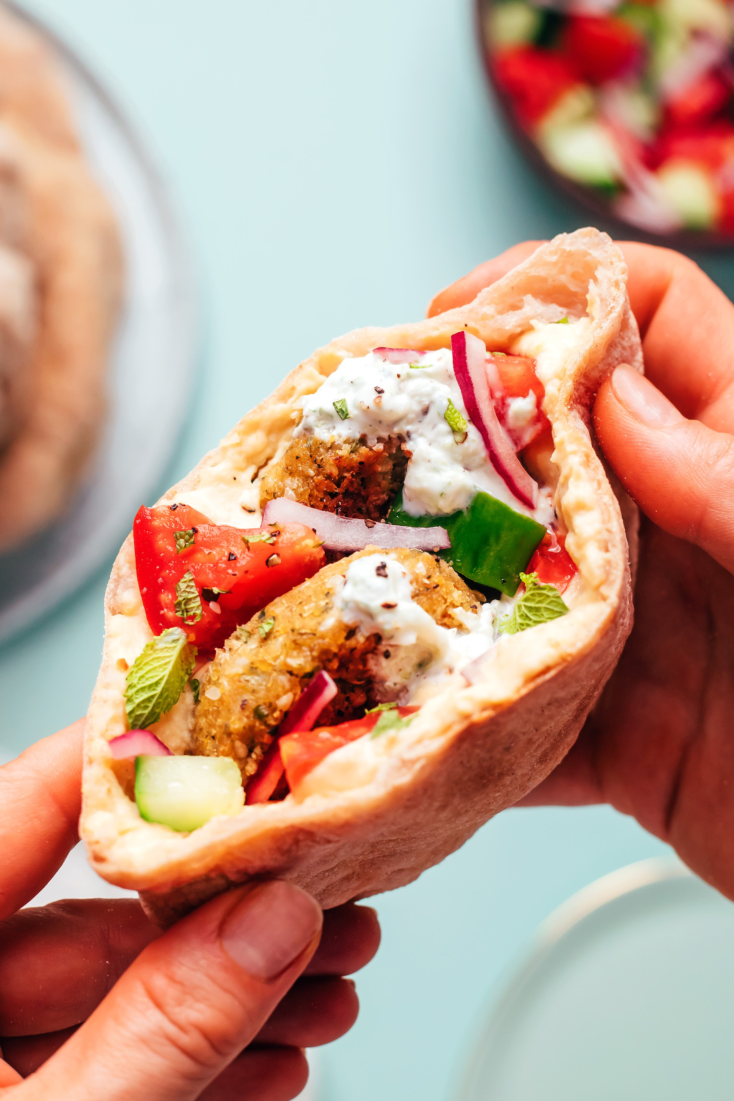 Gluten-free pita pocket stuffed with falafel, tzatziki, cucumber, tomato, red onion, and mint