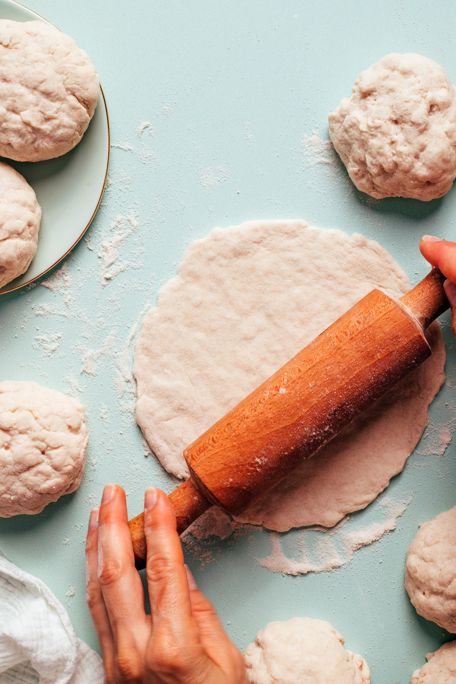 Using a rolling pin to roll out a piece of gluten-free pita dough