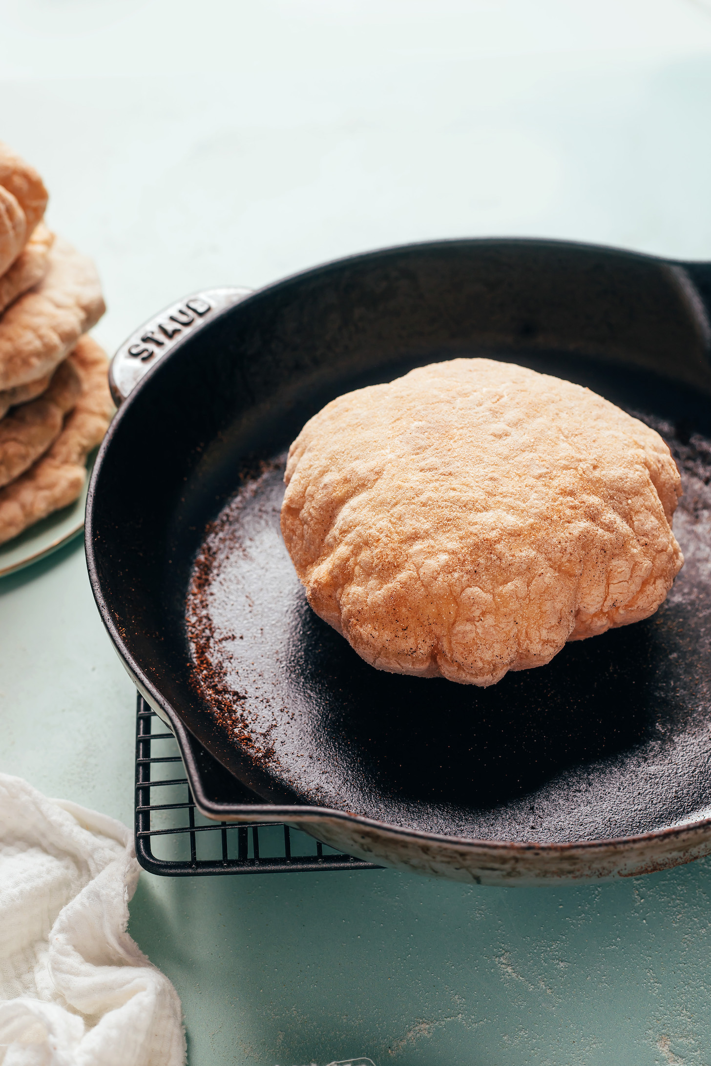 Pillowy gluten-free pita puffed up in a cast iron skillet