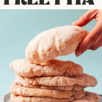 Hand reaching in to pick up pita from a stack with text above it that says vegan and dairy-free pillowy gluten-free pita