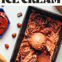 Overhead photo of a loaf pan of our vegan nutella ice cream with text above that says so fluffy and creamy